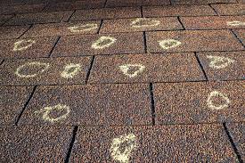 Close-up of large hailstones impacting an asphalt-shingle roof during a storm