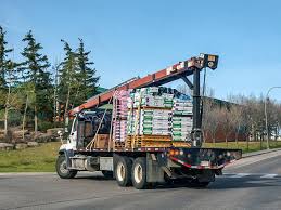 Roofing contractor truck driving a rural highway under a clearing storm sky